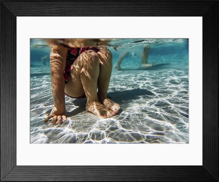 Framed Print : Girls legs underwater at pool on hot summer day