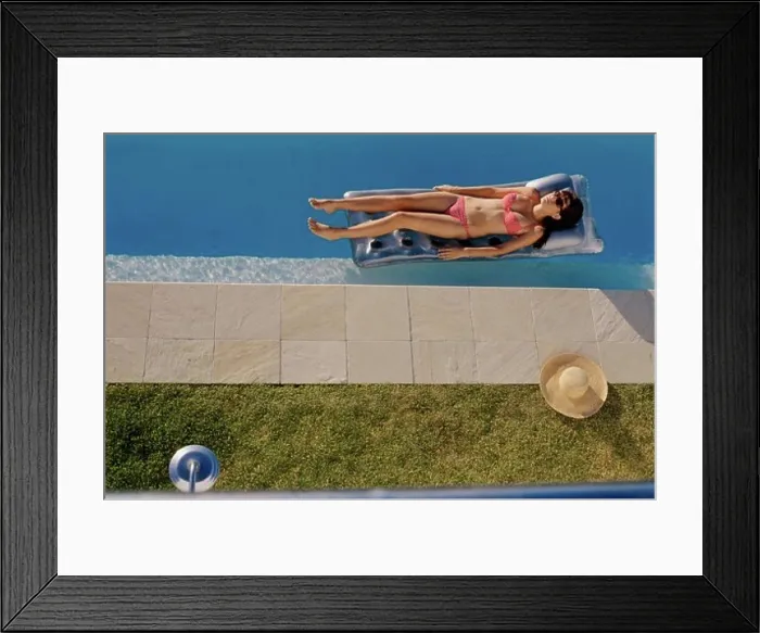 Framed Print : High angle view of a young woman lying on a pool raft Framed Print : High angle view of a young woman lying on a pool raft