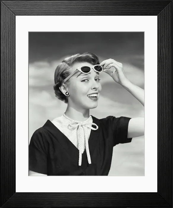 Framed Print : Close-up of young woman holding sunglasses Framed Print : Close-up of young woman holding sunglasses