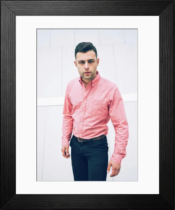 Framed Print : Portrait of serious welldressed businessman standing against wall
