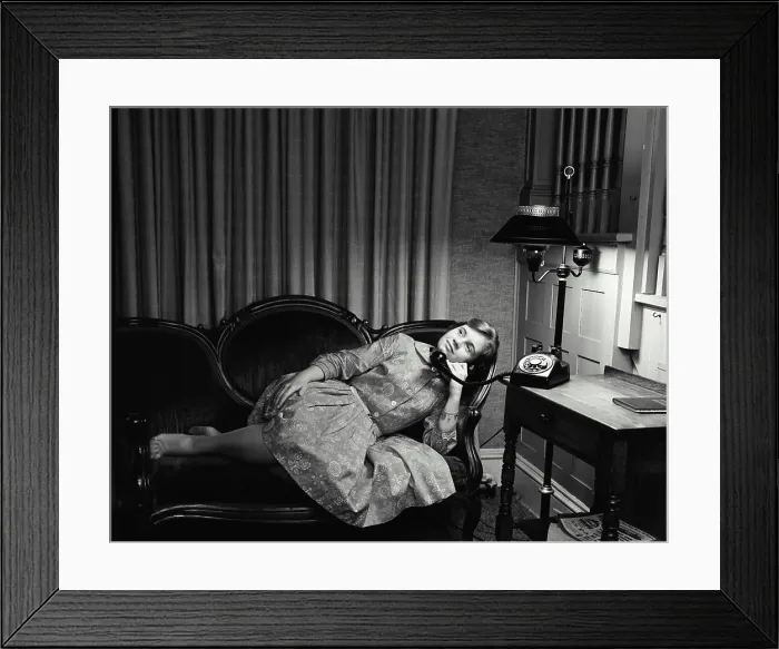 Framed Print : Teenage girl lying on a couch and talking on the telephone Framed Print : Teenage girl lying on a couch and talking on the telephone