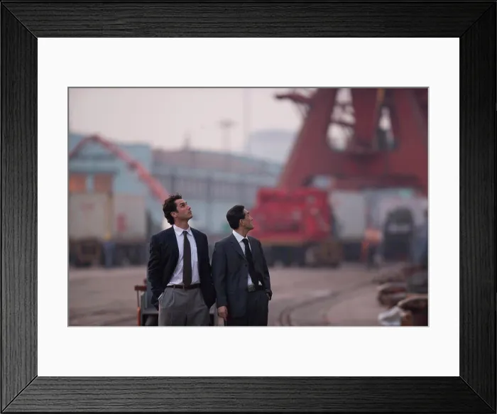Framed Print : Young adult businessman and a mid-adult male colleague walking along a shipping yard Framed Print : Young adult businessman and a mid-adult male colleague walking along a shipping yard