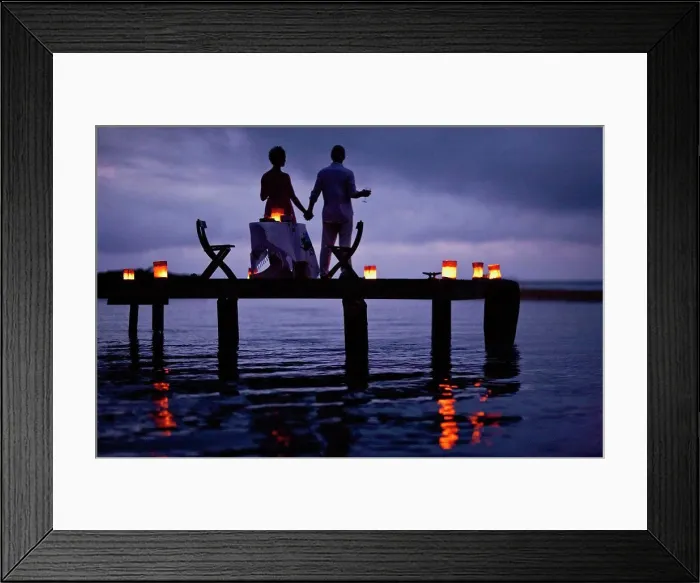 Framed Print : Mature couple enjoying their date on the pier at twilight Framed Print : Mature couple enjoying their date on the pier at twilight