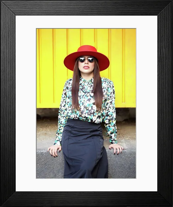 Framed Print : Stylish young hispanic woman looking at camera on a yellow wall Framed Print : Stylish young hispanic woman looking at camera on a yellow wall