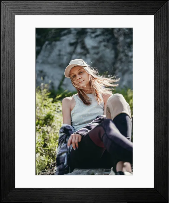 Framed Print : a girl in a gray top and a white cap sits on a stone Framed Print : a girl in a gray top and a white cap sits on a stone