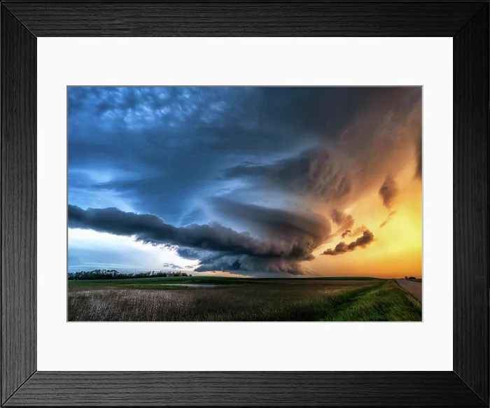 Framed Print : Spinning mesocyclone tornado warned storm over rural gravel road and field at sunset in Saskatechewan Canada