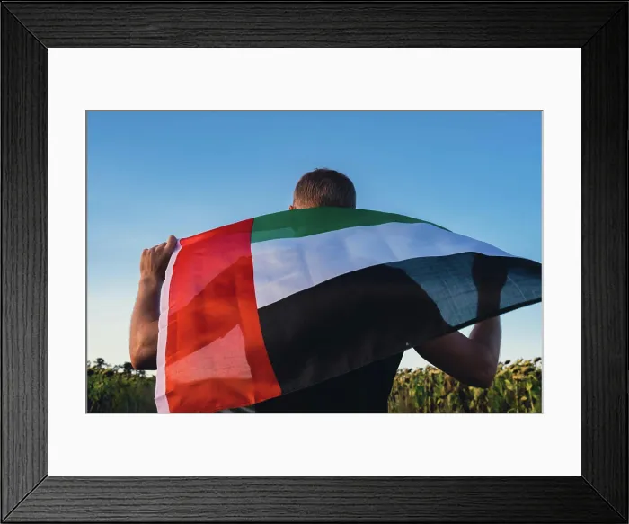 Framed Print : Man holding National Flag Of UAE Waving In The Wind sunset Framed Print : Man holding National Flag Of UAE Waving In The Wind sunset