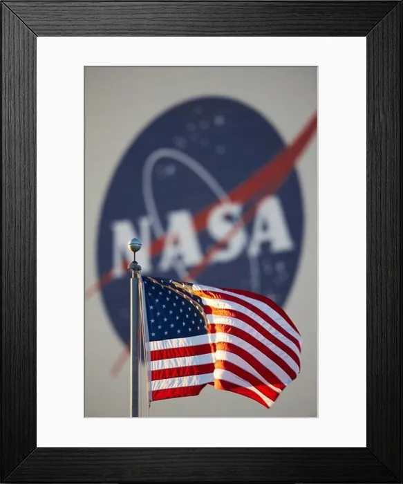 Framed Print : American flag in foreground and large NASA insignia on the side of the Vehicle Assembly Building (VAB)
