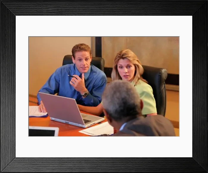 Framed Print : Two businessmen and a businesswoman sitting in a conference room Framed Print : Two businessmen and a businesswoman sitting in a conference room