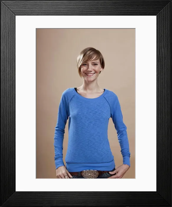 Framed Print : Portrait of a woman smiling in anticipation, studio shot Framed Print : Portrait of a woman smiling in anticipation, studio shot