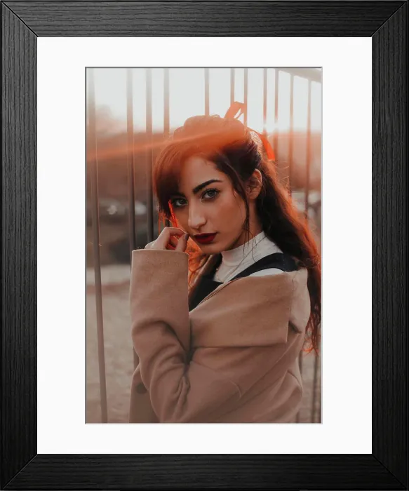 Framed Print : Attractive young brunette woman standing on street and looking at camera