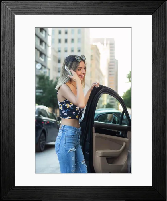 Framed Print : young wealthy Hispanic woman wearing floral top with torn blue jeans, getting into car on busy city street Framed Print : young wealthy Hispanic woman wearing floral top with torn blue jeans, getting into car on busy city street
