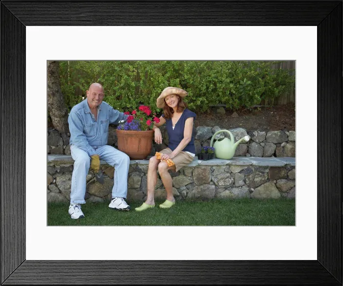 Framed Print : Portrait of a mature couple sitting in a garden and smiling