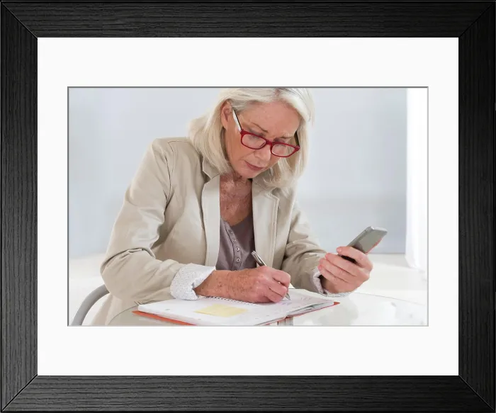 Framed Print : Senior woman writing in an appointments diary Framed Print : Senior woman writing in an appointments diary