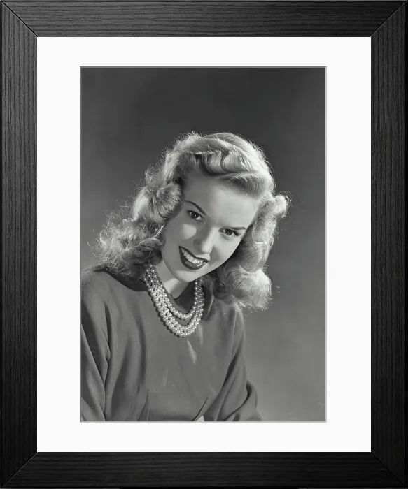 Framed Print : Vintage photograph. Blonde woman with wavy hair wearing blouse and pearl necklace smiling Framed Print : Vintage photograph. Blonde woman with wavy hair wearing blouse and pearl necklace smiling
