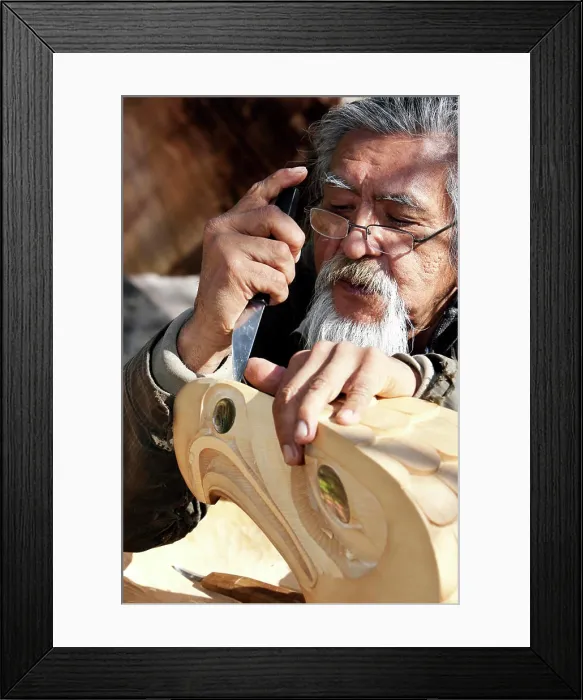 Framed Print : A First Nations carver works on an Eagle piece