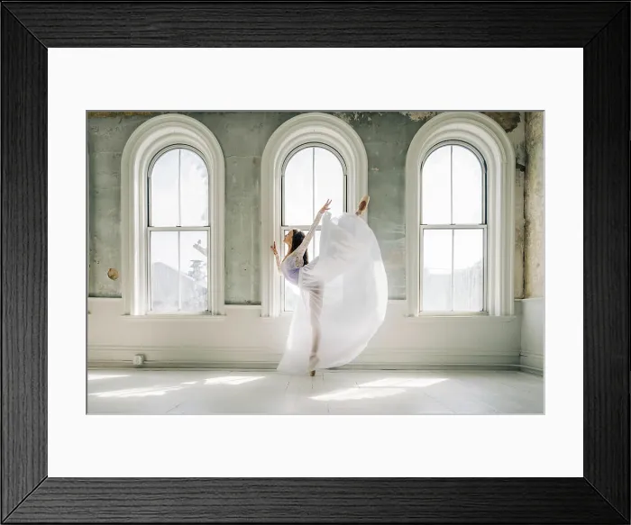 Framed Print : Ballet dancer in a flowing white dress performs a graceful arabesque Framed Print : Ballet dancer in a flowing white dress performs a graceful arabesque
