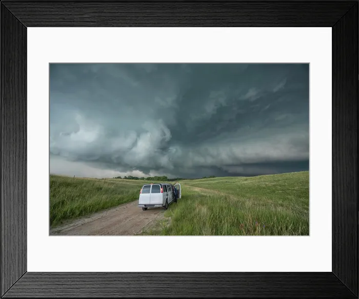 Framed Print : Vehicle sits on an off-road in the countryside as people photograph