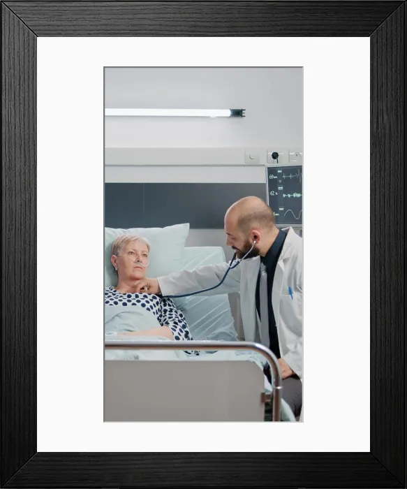 Framed Print : Doctor consulting sick patient with stethoscope in hospital ward
