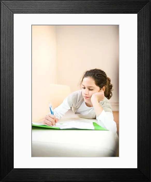 Framed Print : Girl writing on sheet of paper Framed Print : Girl writing on sheet of paper