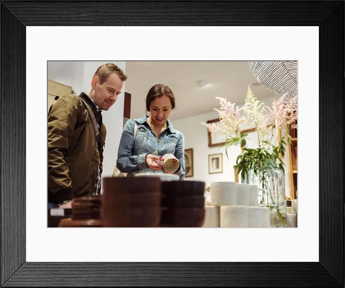 Framed Print : Smiling couple choosing crockery at boutique Framed Print : Smiling couple choosing crockery at boutique