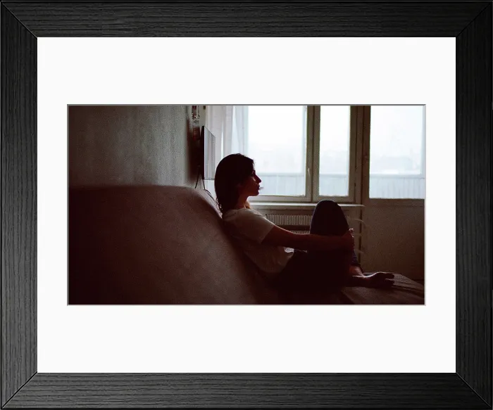 Framed Print : Portrait of a woman who is sitting on a sofa Framed Print : Portrait of a woman who is sitting on a sofa