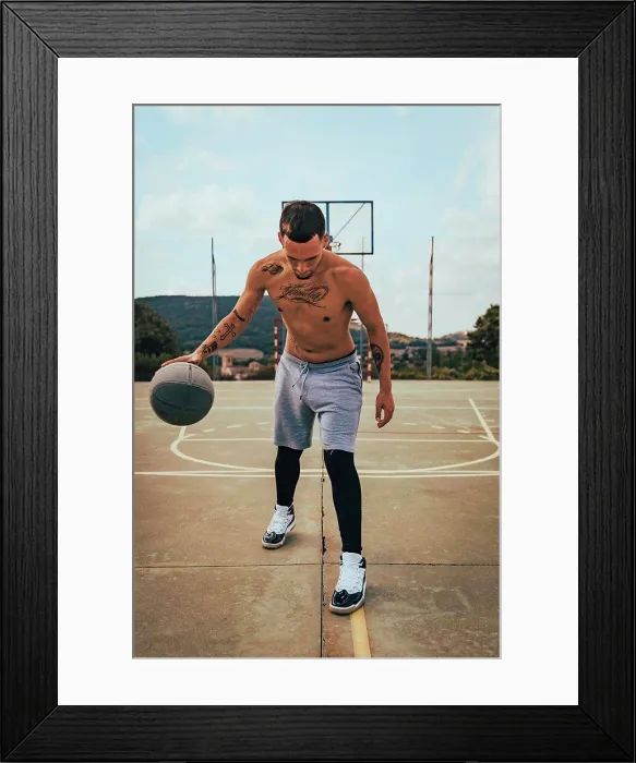 Framed Print : Young tattooed Latino boy playing with a basketball on a court Framed Print : Young tattooed Latino boy playing with a basketball on a court