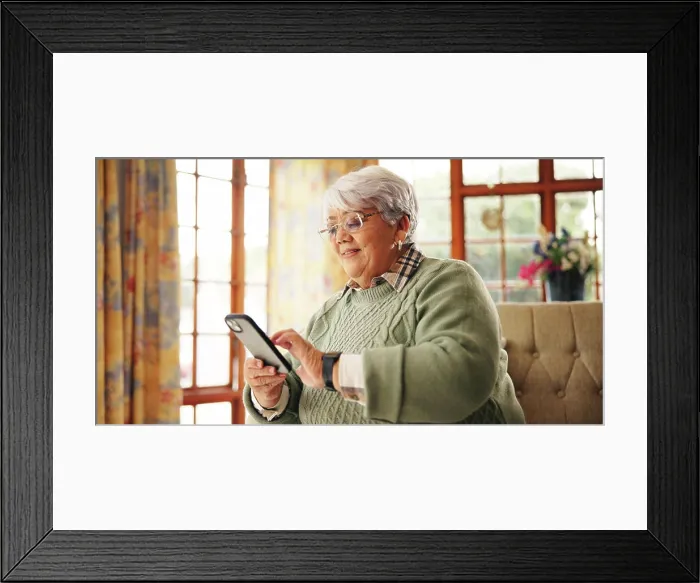 Framed Print : Senior woman, scroll or phone on sofa for online news Framed Print : Senior woman, scroll or phone on sofa for online news