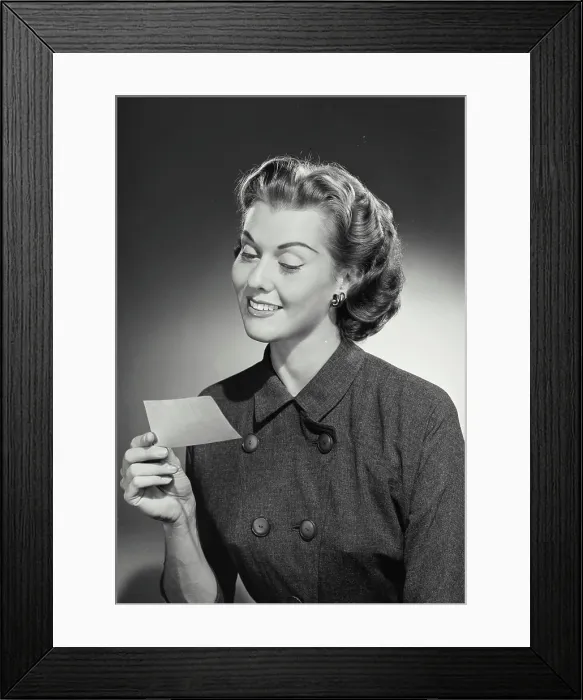 Framed Print : Vintage Photograph. Woman in coat smiling at slip of paper Framed Print : Vintage Photograph. Woman in coat smiling at slip of paper