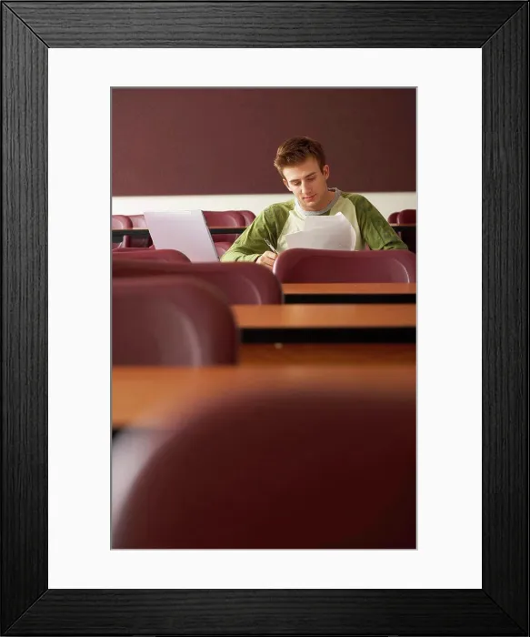 Framed Print : College student sitting in a lecture hall and studying Framed Print : College student sitting in a lecture hall and studying