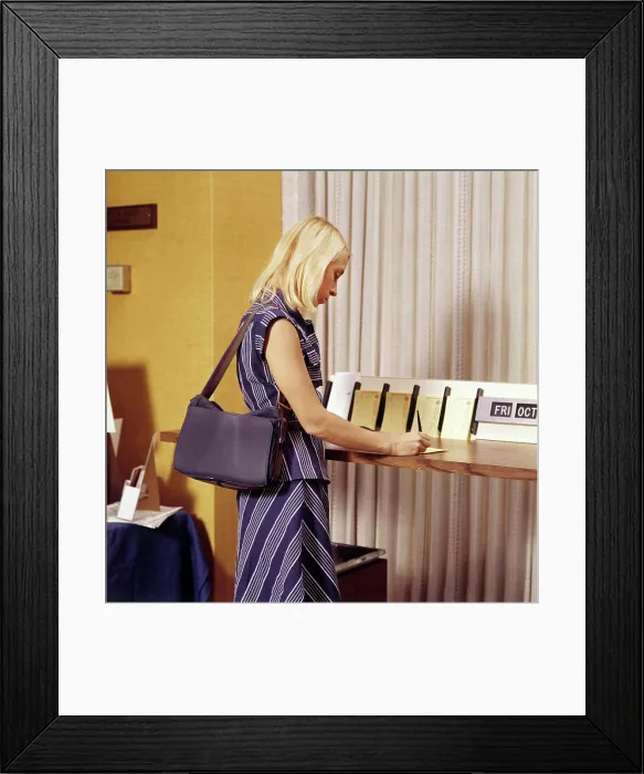 Framed Print : 1970S Blond Woman Writing A Deposit Slip At Counter In Bank Framed Print : 1970S Blond Woman Writing A Deposit Slip At Counter In Bank