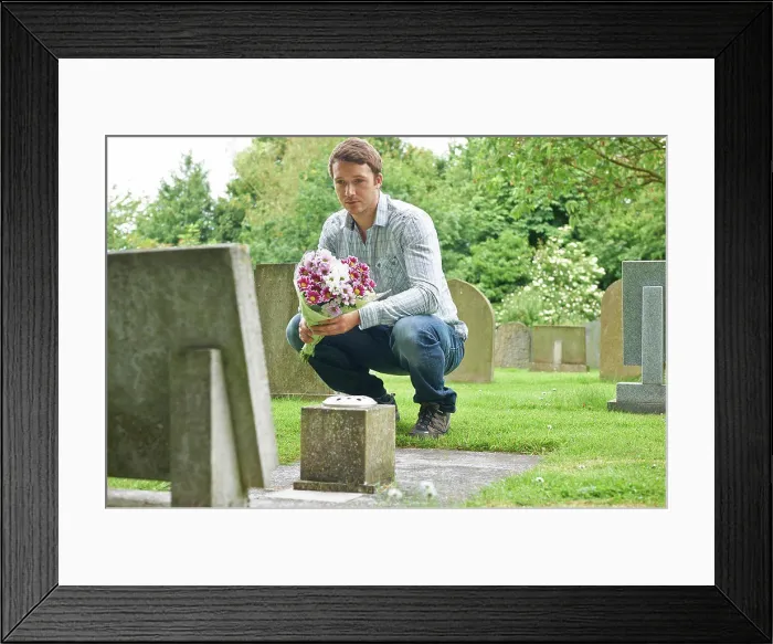 Framed Print : Man Placing Flowers By Headstone In Cemetery Framed Print : Man Placing Flowers By Headstone In Cemetery
