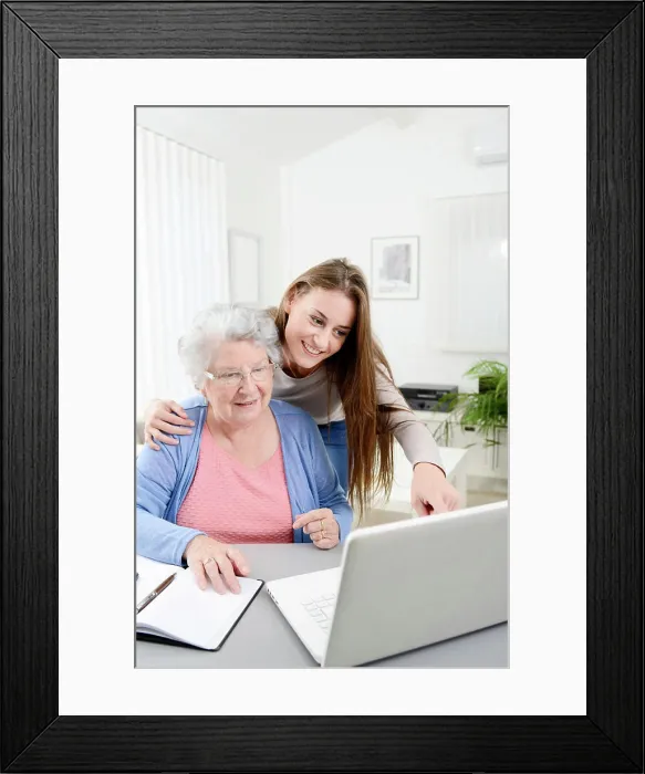 Framed Print : Young woman helping old senior woman doing paperwork and administrative procedures with laptop computer at home Framed Print : Young woman helping old senior woman doing paperwork and administrative procedures with laptop computer at home