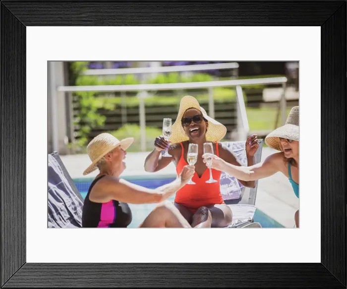 Framed Print : Happy senior women friends drinking champagne at sunny summer poolside Framed Print : Happy senior women friends drinking champagne at sunny summer poolside
