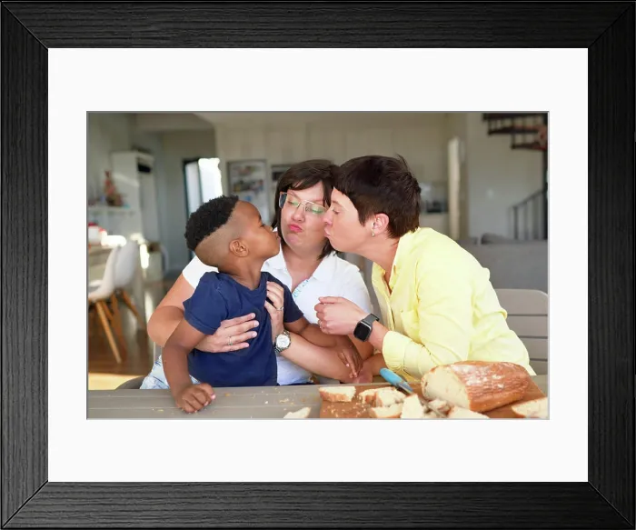 Framed Print : Lesbian couple and cute son puckering lips at dinner table Framed Print : Lesbian couple and cute son puckering lips at dinner table