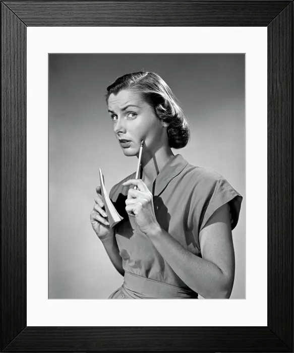 Framed Print : Thoughtful young woman holding pen and notepad Framed Print : Thoughtful young woman holding pen and notepad