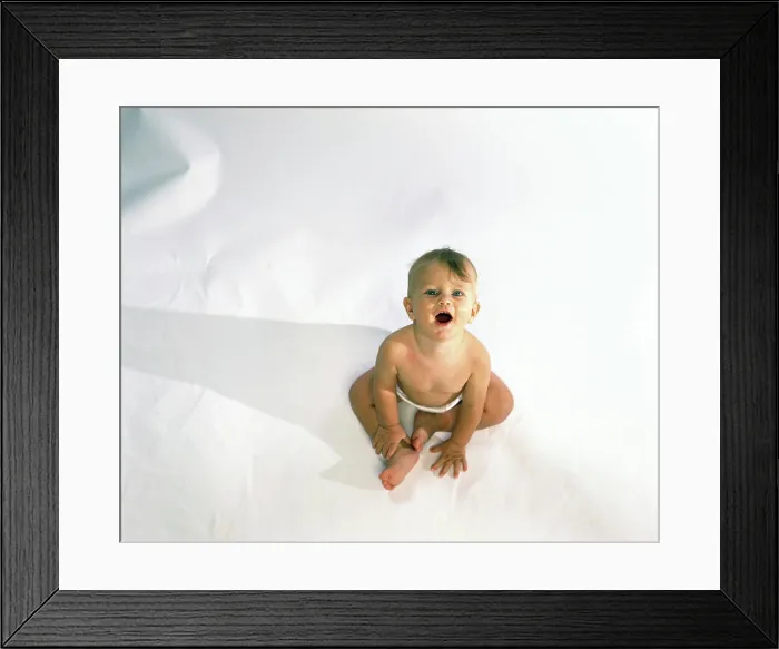 Framed Print : High angle view of a baby sitting and looking up Framed Print : High angle view of a baby sitting and looking up