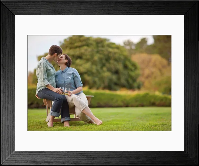 Framed Print : Mid adult couple sitting on a chair and kissing Framed Print : Mid adult couple sitting on a chair and kissing
