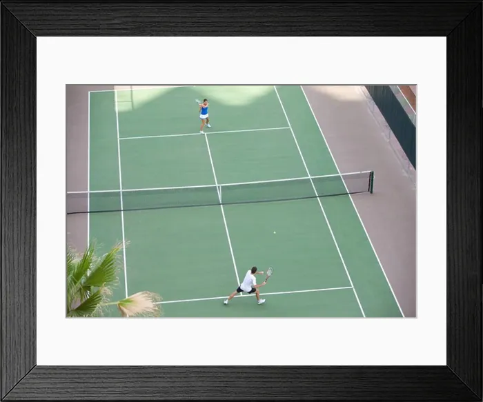 Framed Print : Young couple playing tennis in the court of a tourist resort Framed Print : Young couple playing tennis in the court of a tourist resort