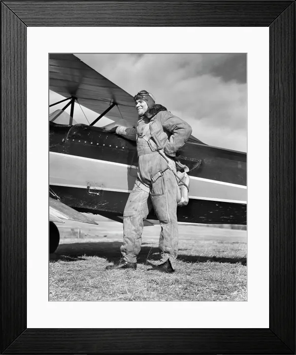 Framed Print : 1940s PORTRAIT SMILING MAN AVIATOR PILOT STANDING BY BIPLANE WEARING CANVAS FLYING SUIT HELMET GOGGLES AND PARACHUTE