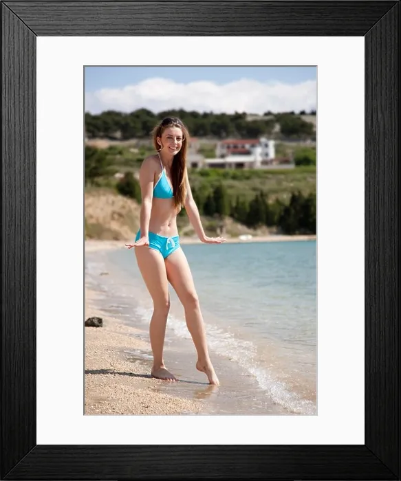 Framed Print : Woman testing water temp at the beach