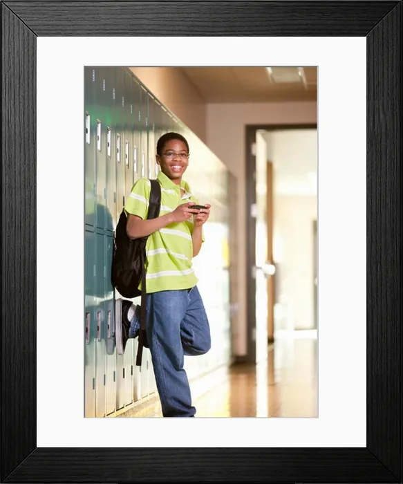 Framed Print : Middle school student text messaging on a mobile phone