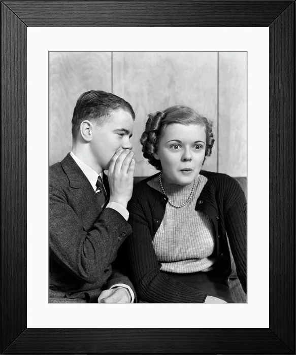 Framed Print : 1940S 1930S Young Teenage Couple Boy Whispering Into Girl'S Ear Girl With Amazed Surprised Expression Framed Print : 1940S 1930S Young Teenage Couple Boy Whispering Into Girl'S Ear Girl With Amazed Surprised Expression