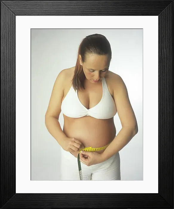 Framed Print : Pregnant woman measuring her belly, waist Framed Print : Pregnant woman measuring her belly, waist