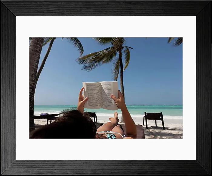 Framed Print : Girl, 16 years, reading a book on the beach under palm trees Framed Print : Girl, 16 years, reading a book on the beach under palm trees