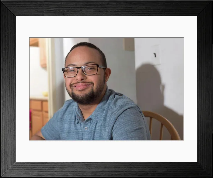 Framed Print : Portrait of happy African American man with Down Syndrome at home Framed Print : Portrait of happy African American man with Down Syndrome at home