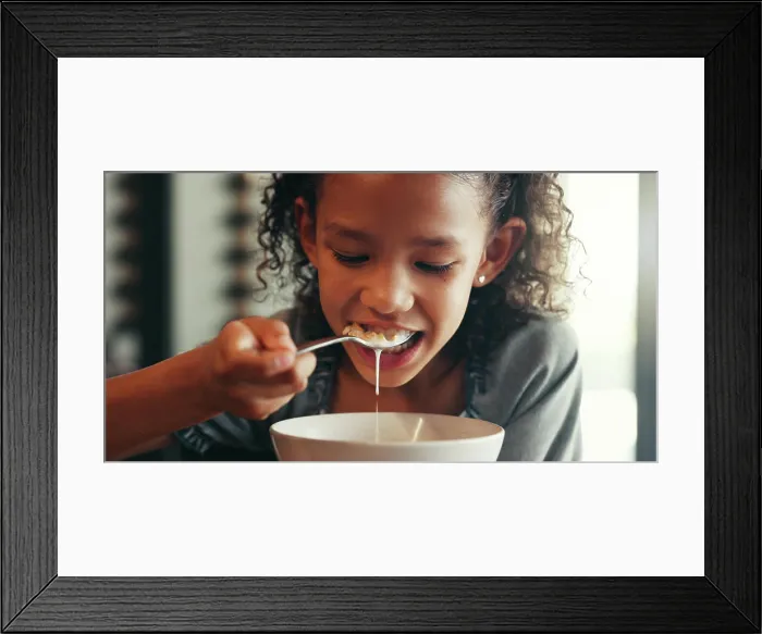 Framed Print : Breakfast, morning and eating with child and cereal at dining table for food Framed Print : Breakfast, morning and eating with child and cereal at dining table for food