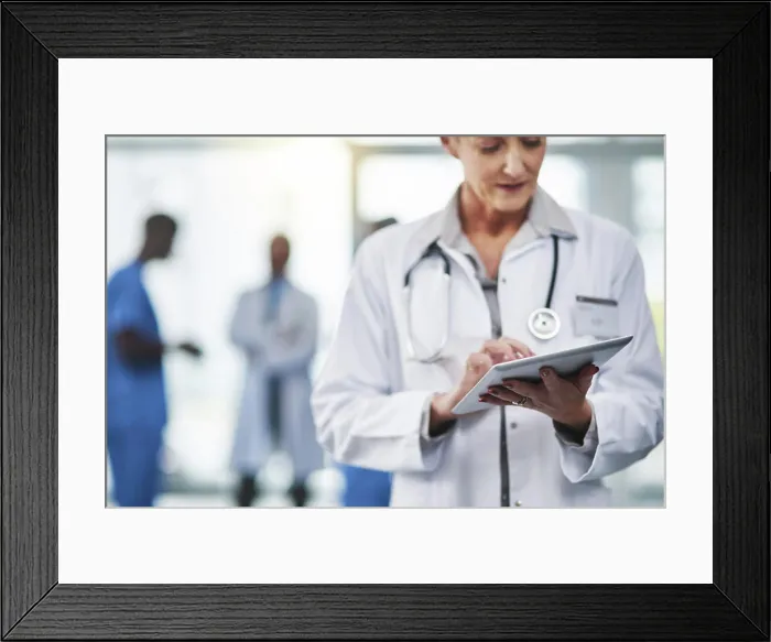 Framed Print : Mature female doctor on a digital tablet at the hospital Framed Print : Mature female doctor on a digital tablet at the hospital