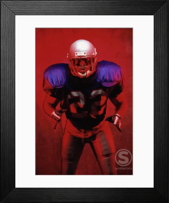 Framed Print : Portrait of an American football player standing in a tackle pose Framed Print : Portrait of an American football player standing in a tackle pose
