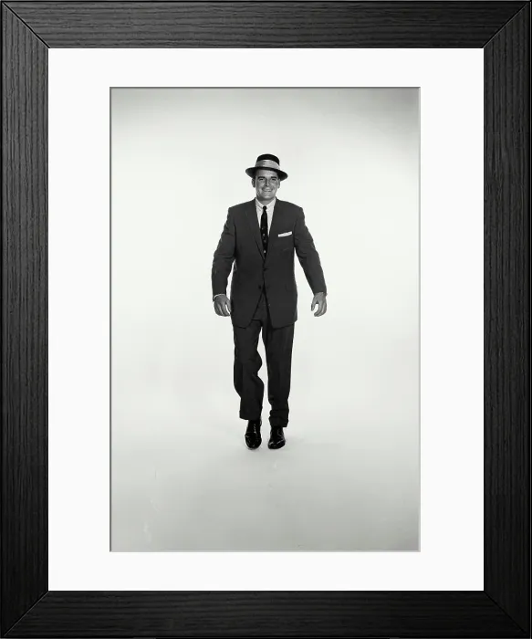 Framed Print : Vintage Photograph. A studio shot of a man in a dark suit walking towards the camera. Frame 3